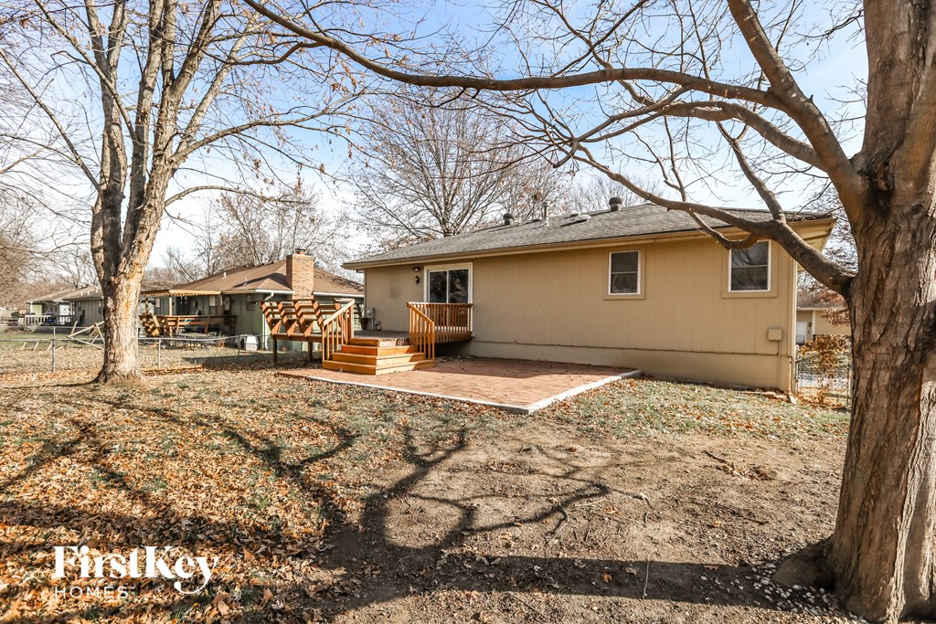 a house with a deck and a yard with trees