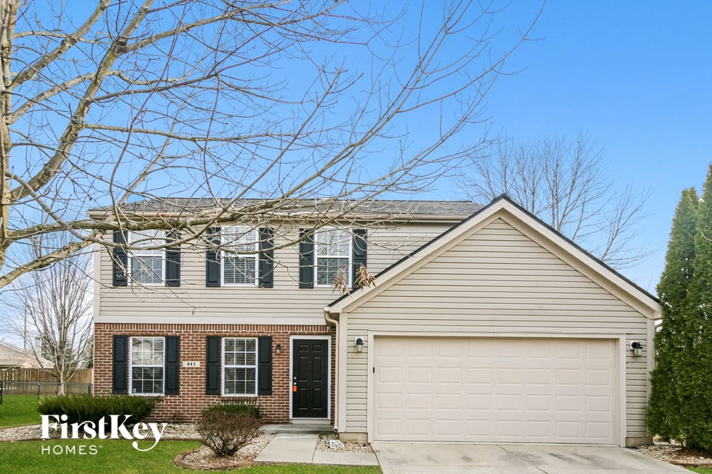 a home with a white garage door and a brick house