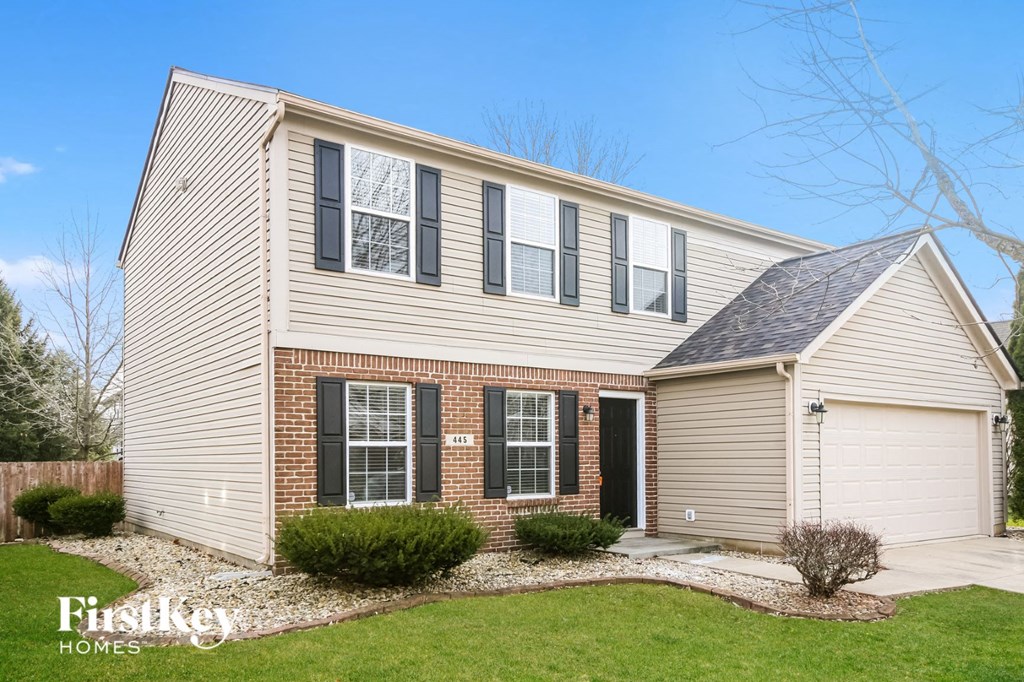 a white house with black shuttered windows and a lawn