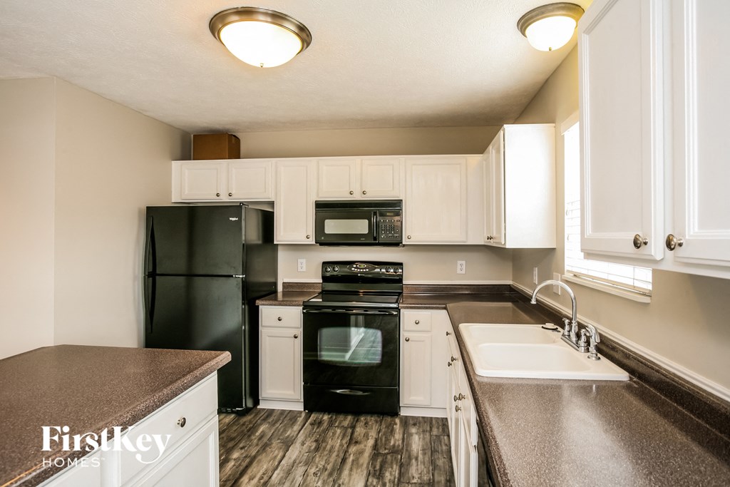 a kitchen with black appliances and white cabinets