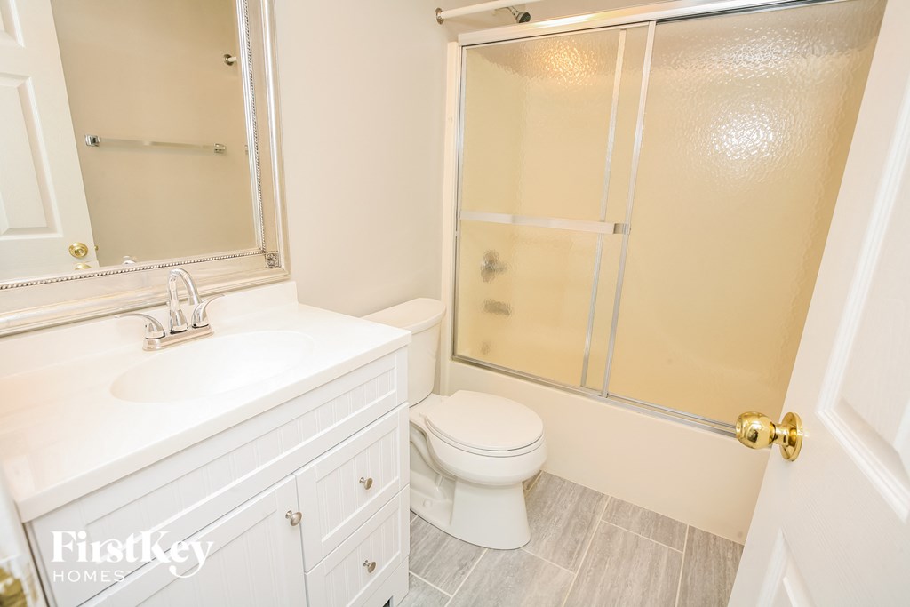 a white bathroom with a shower toilet and sink