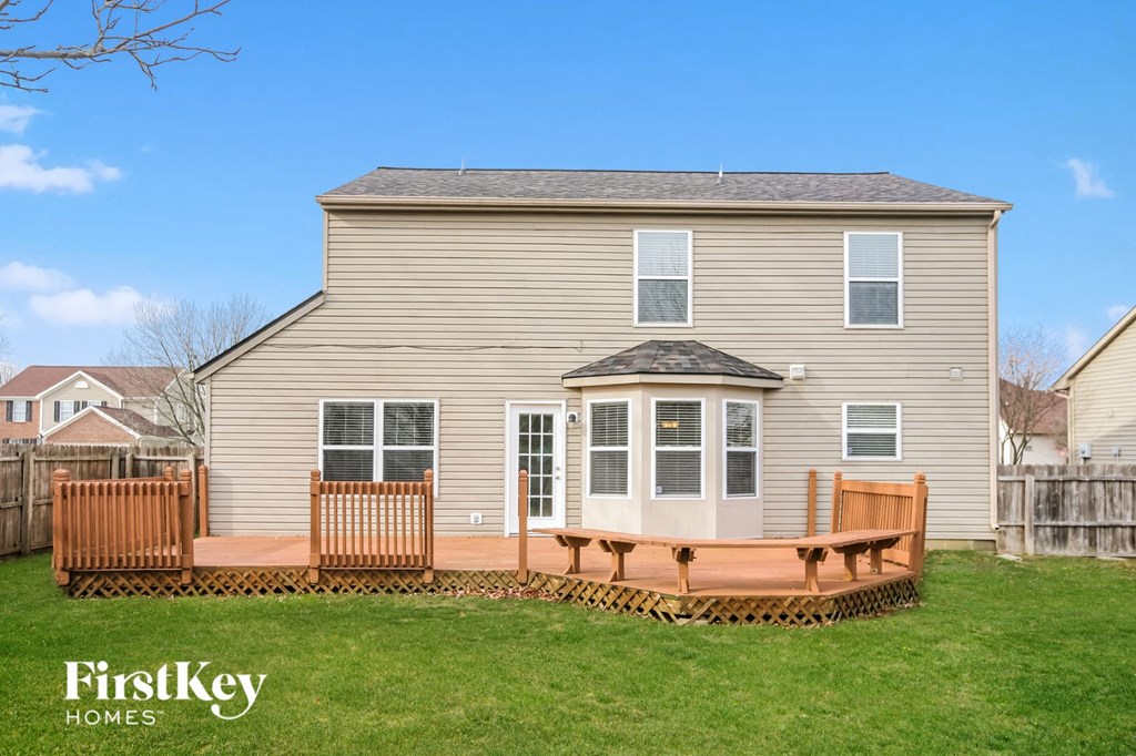 a backyard deck with a wooden fence and a house