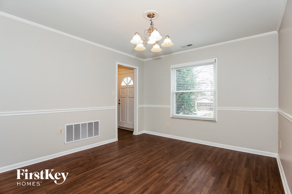 the living room of an empty house with wood flooring and a window
