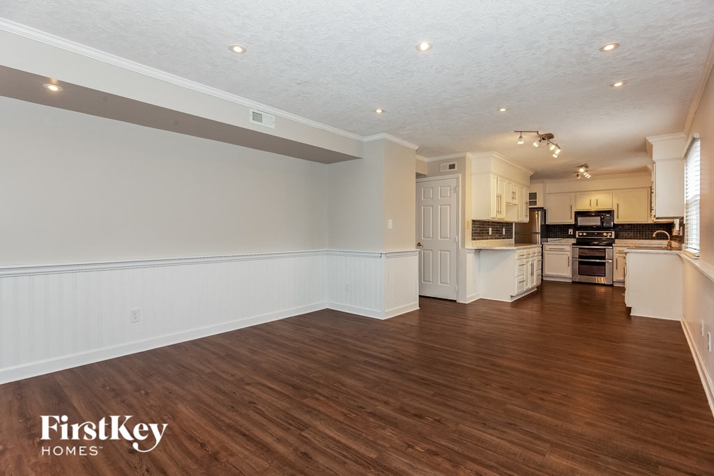 a kitchen and living room with wood floors and white walls