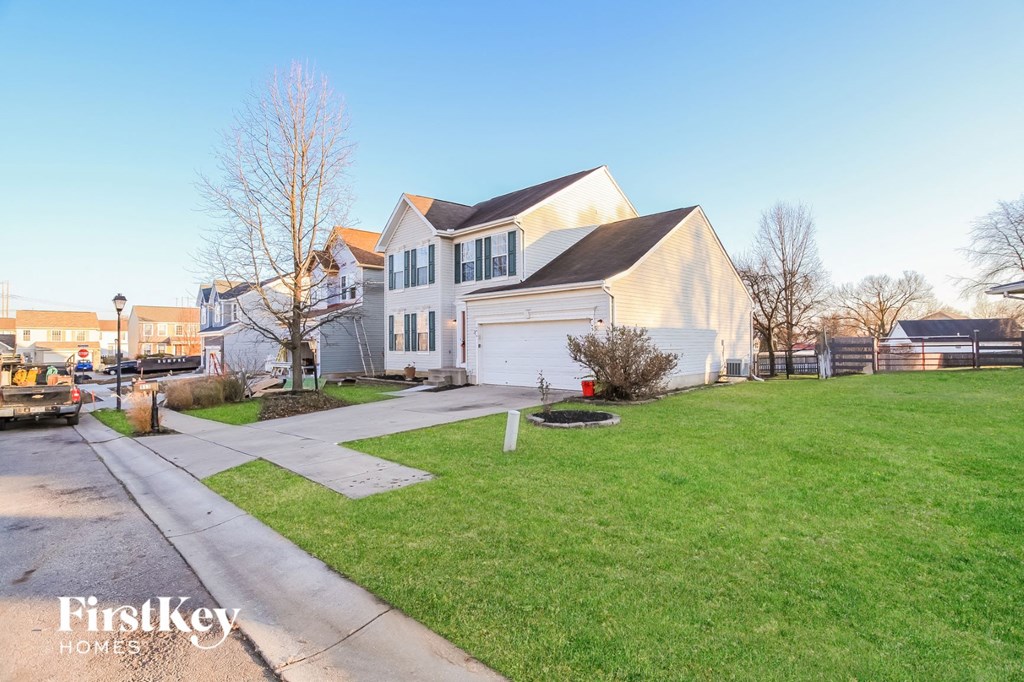 the front of a house with a lawn and a driveway