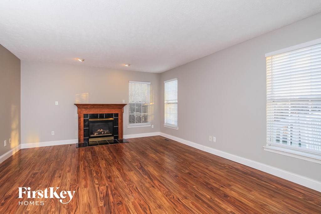 the living room with wood flooring and a fireplace