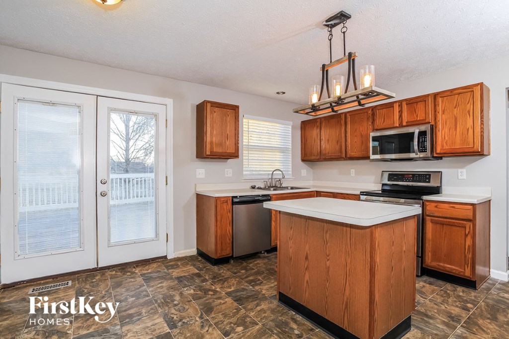 a kitchen with wooden cabinets and a door to a patio