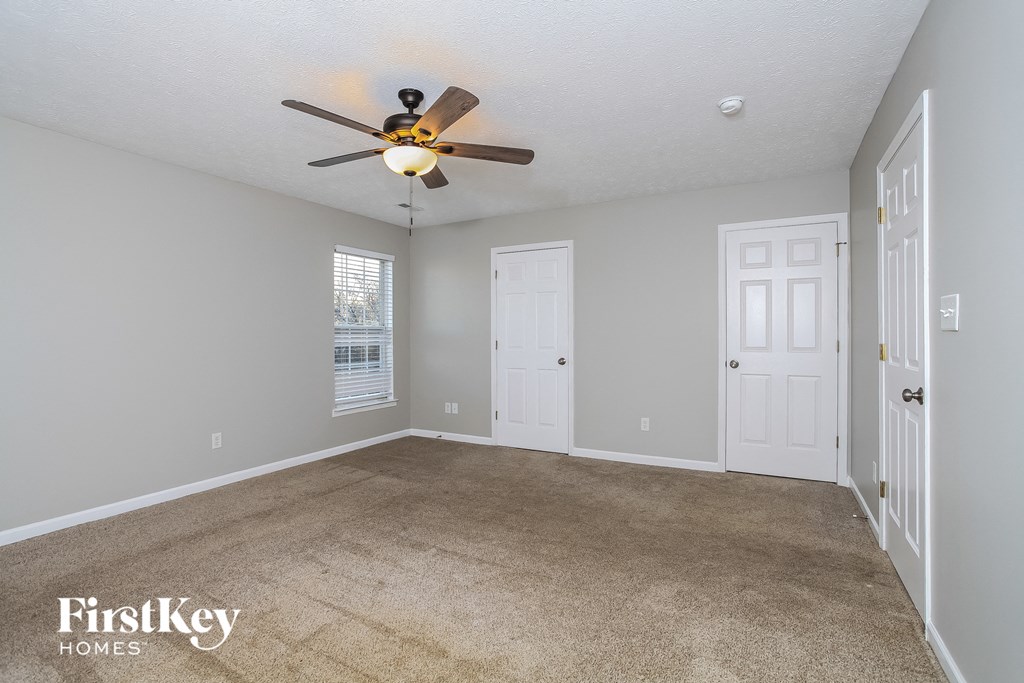 a living room with carpet and a ceiling fan