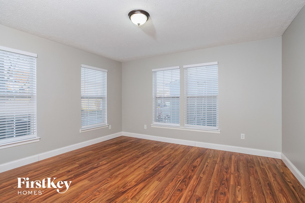 the living room of a house with wood floors and windows