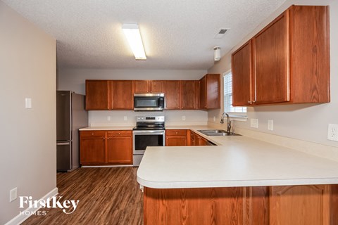 A kitchen with wooden cabinets and a white countertop.