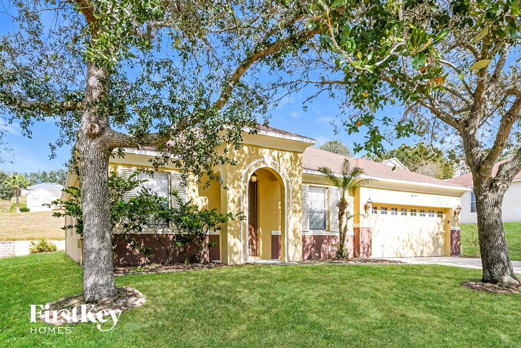 a yellow house with a tree in front of it