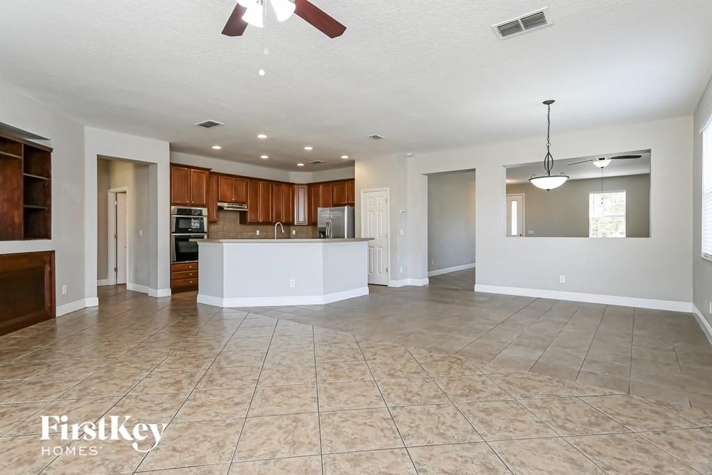 an open kitchen and living room with tile flooring