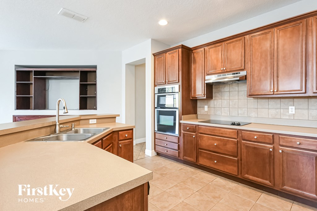 a kitchen with wooden cabinets and a counter top and a sink