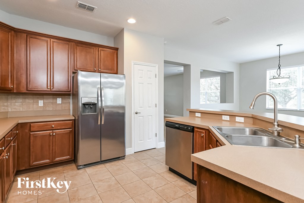 a kitchen with wooden cabinets and stainless steel appliances