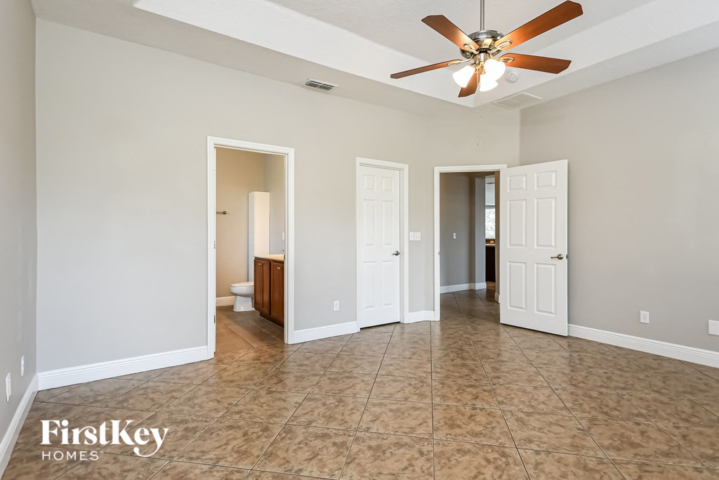 an empty living room with a ceiling fan
