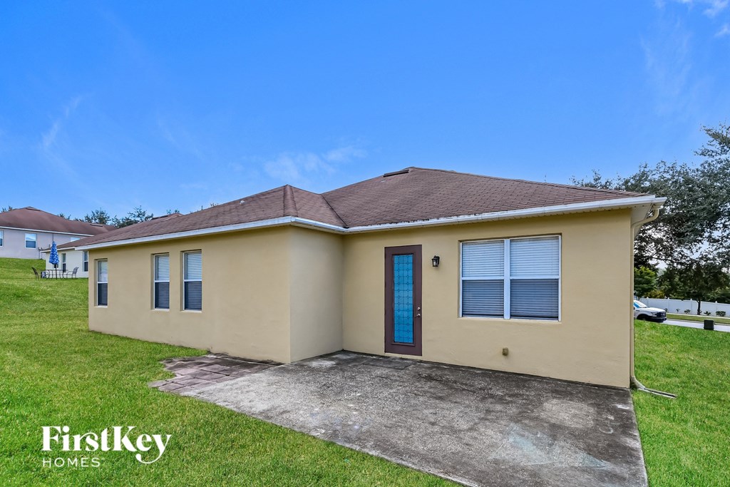 a beige house with a blue door and a driveway