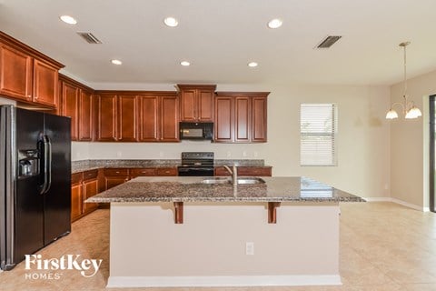 A kitchen with brown cabinets and a granite countertop.