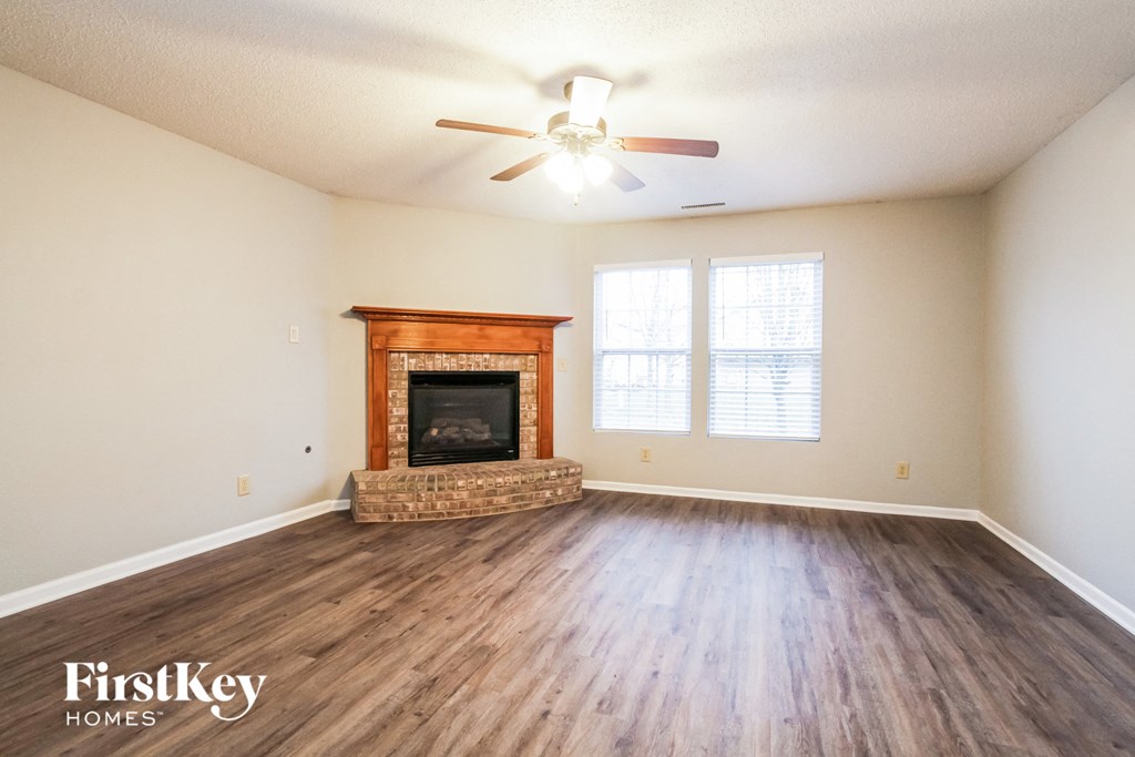 the living room with wood flooring and a fireplace