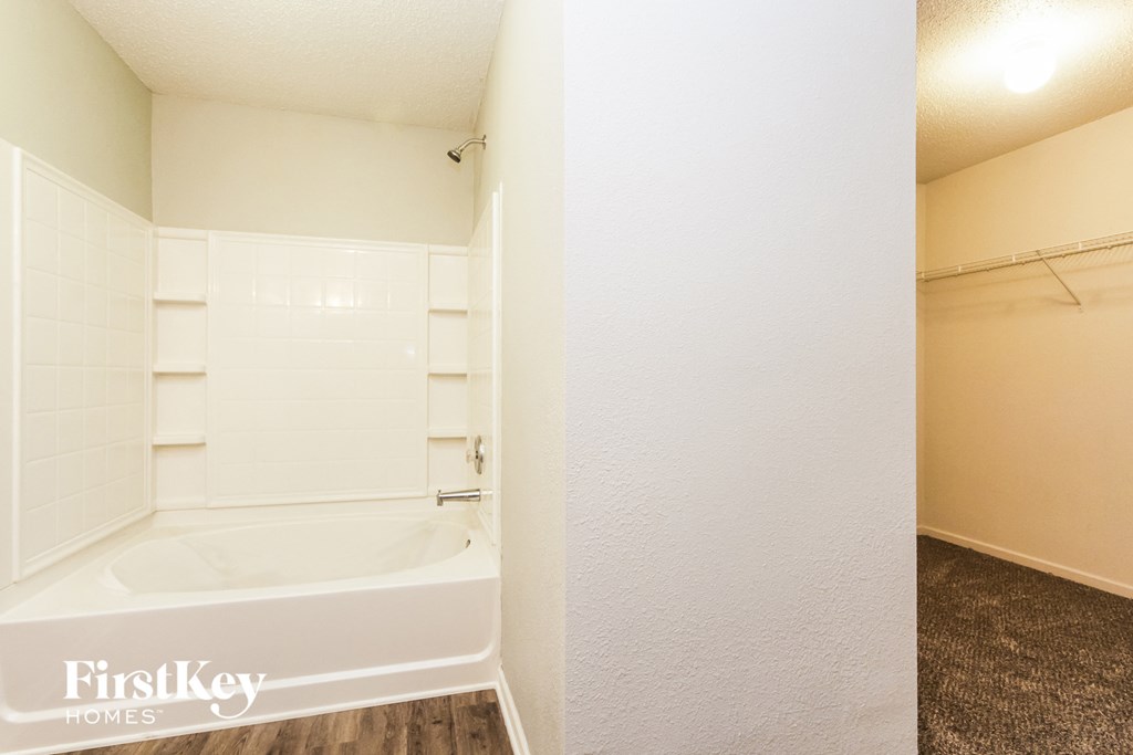 a bathroom with a tub and a shower in it