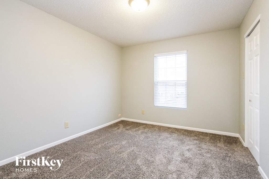 a spacious room with carpet and a window