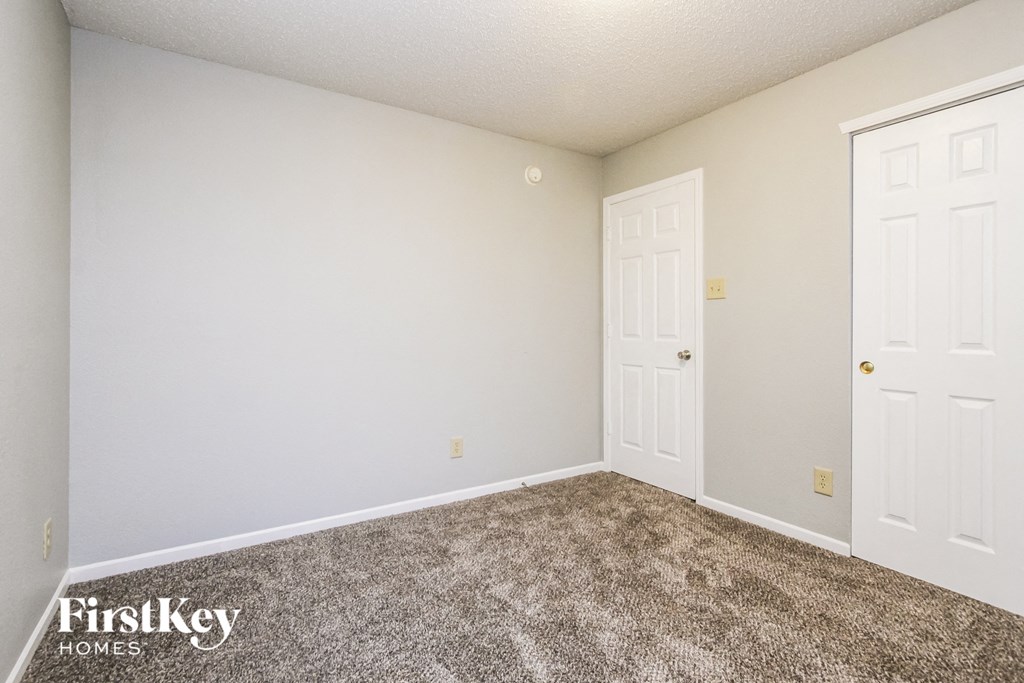 a bedroom with a carpeted floor and white doors