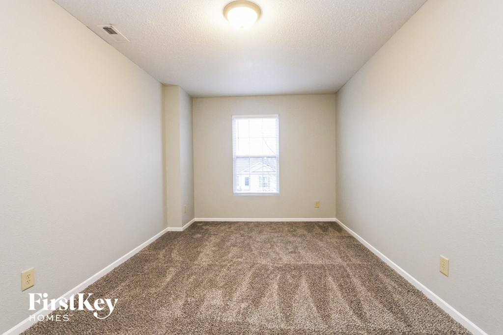 an empty room with carpet and a window