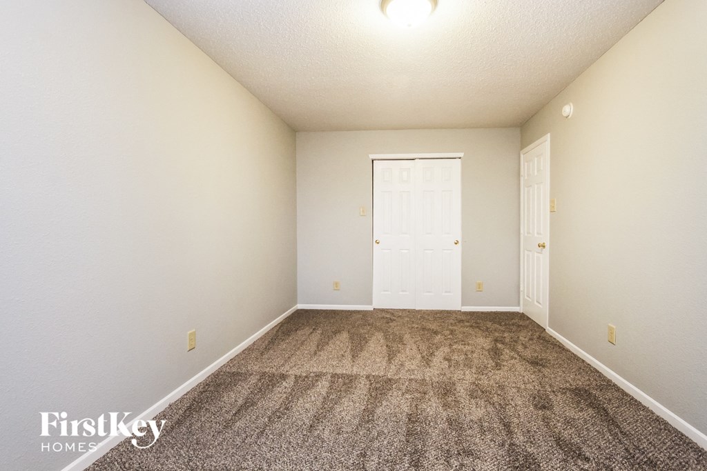 an empty room with carpet and a white door