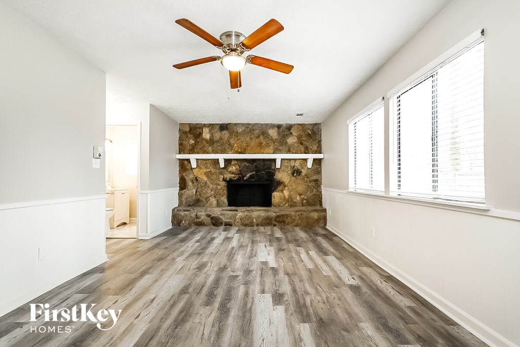 A room with a fireplace and a ceiling fan.