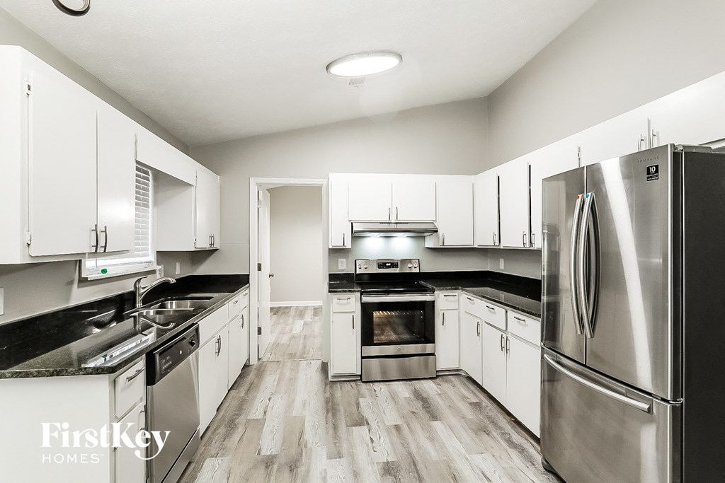 A modern kitchen with stainless steel appliances and white cabinets.