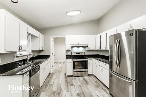 A modern kitchen with stainless steel appliances and white cabinets.
