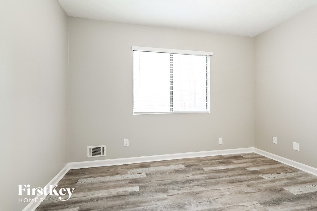 A room with a window and wooden flooring.
