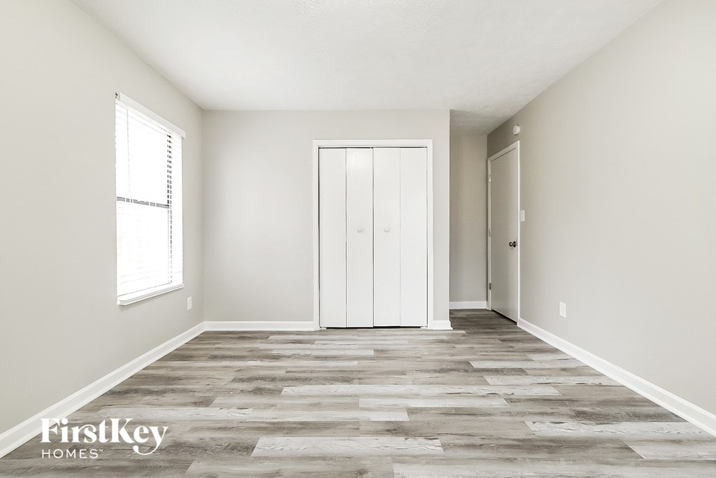 A room with a wooden floor and a white door.
