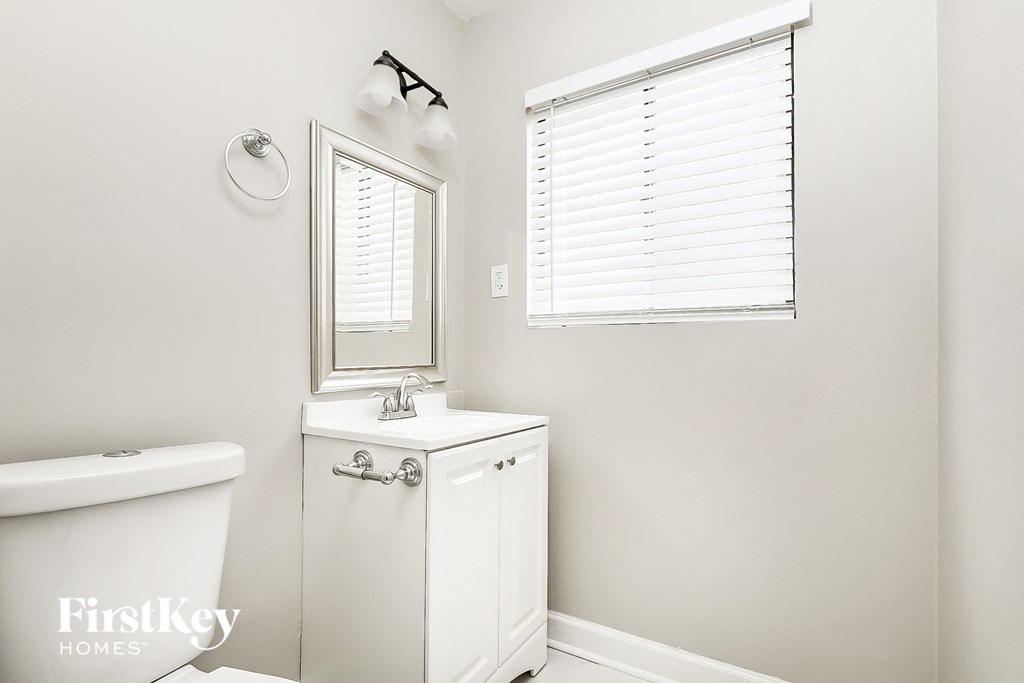 A white bathroom with a tub, sink, and medicine cabinet.