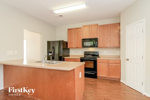 A kitchen with wooden cabinets and a brown counter.