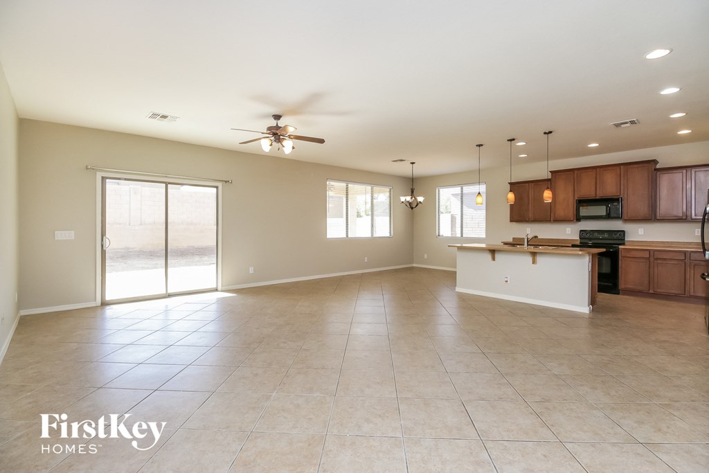 an empty kitchen and living room with a ceiling fan