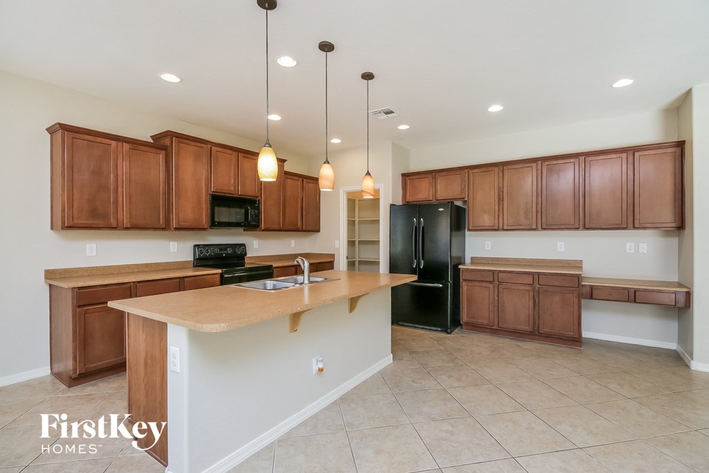 an empty kitchen with wooden cabinets and a large counter top