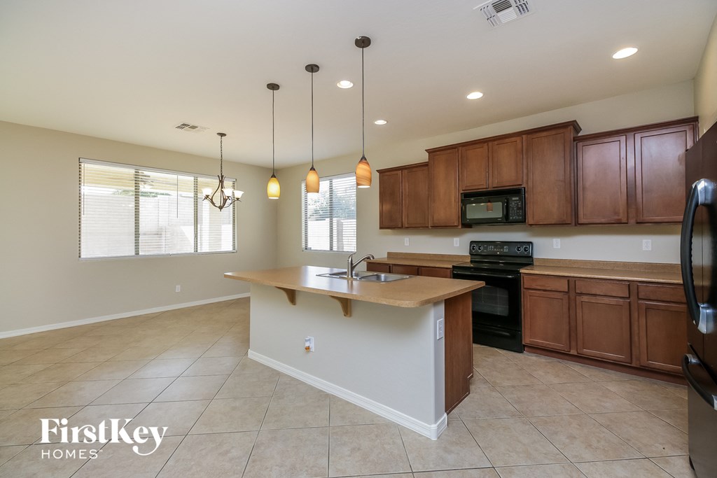 a kitchen with wooden cabinets and an island with a sink
