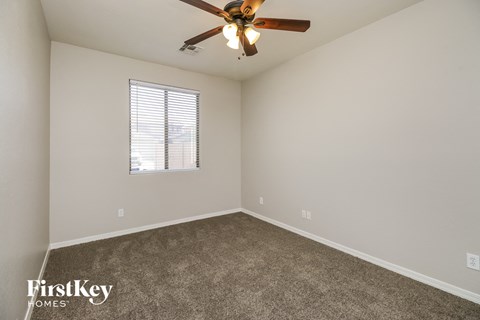 a bedroom with carpet and a ceiling fan