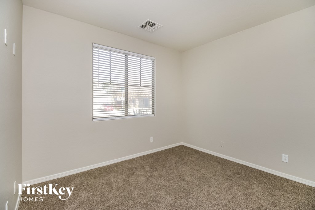 a spacious room with carpet and a window