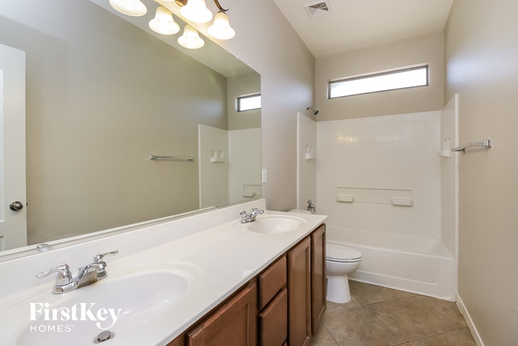 a bathroom with a large mirror and a sink and a toilet