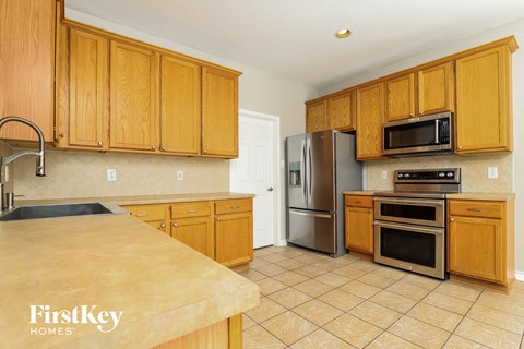 a kitchen with wooden cabinets and stainless steel appliances