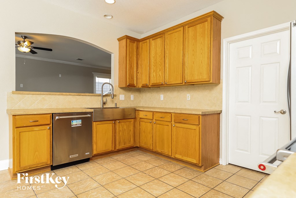 a kitchen with wooden cabinets and a stainless steel dishwasher