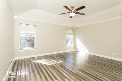 a living room with wood floors and a ceiling fan