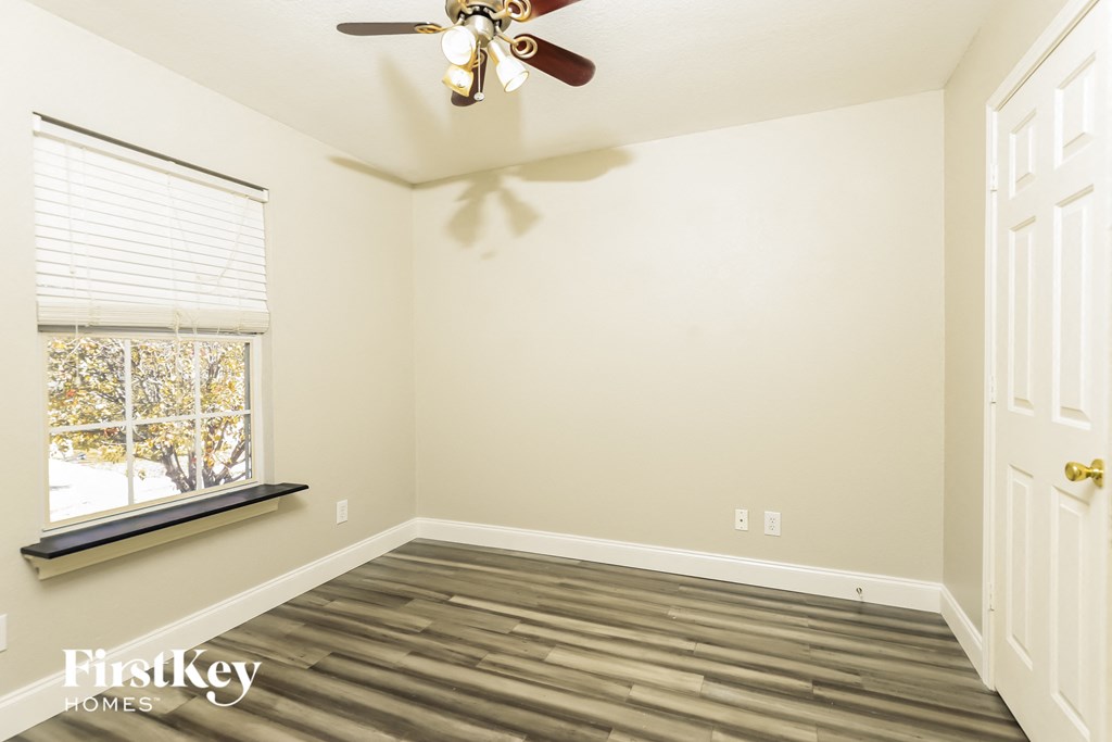 a empty room with a ceiling fan and a window