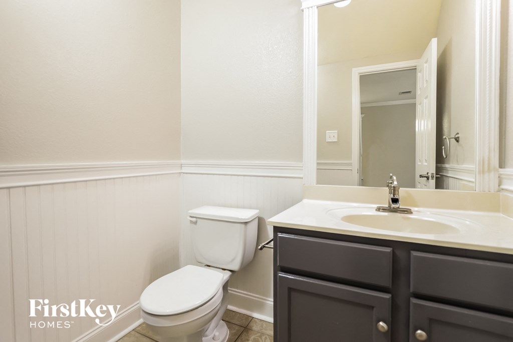 a bathroom with a toilet and a sink and a mirror