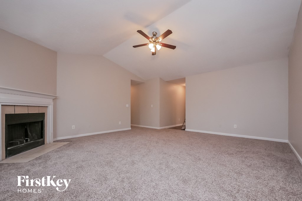 the living room has a fireplace and a ceiling fan