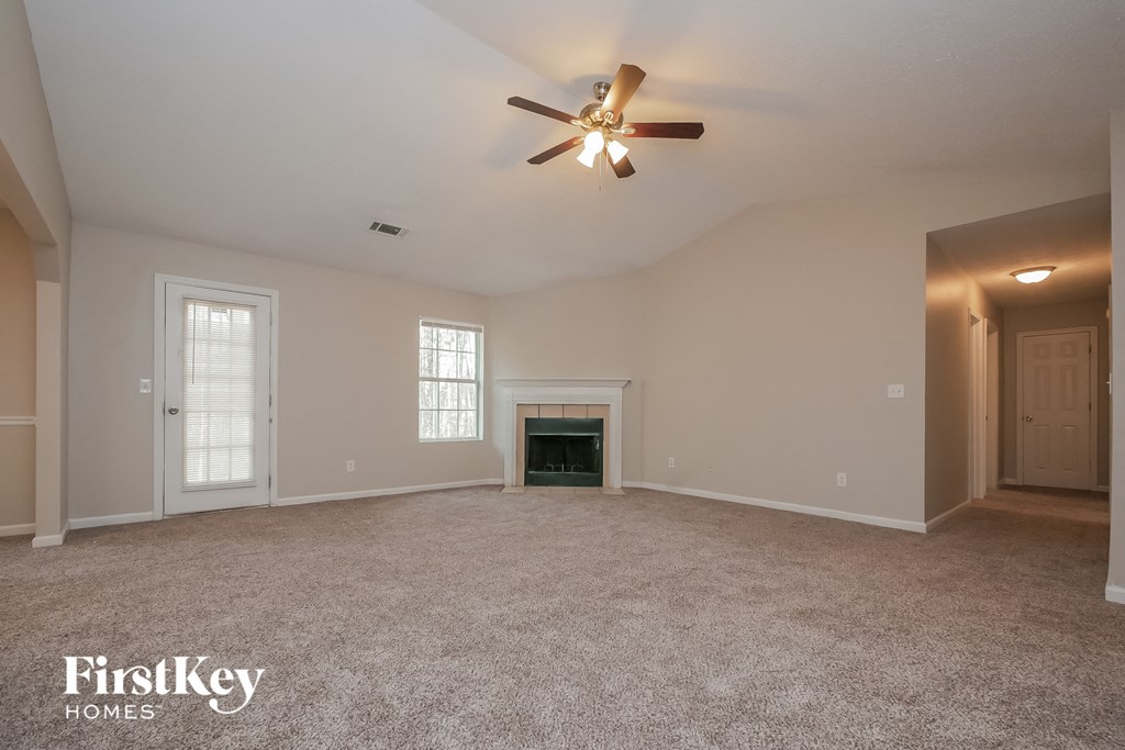 the living room of an empty house with a ceiling fan
