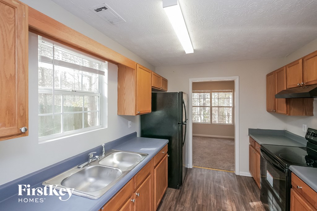 a kitchen with a sink and a black refrigerator