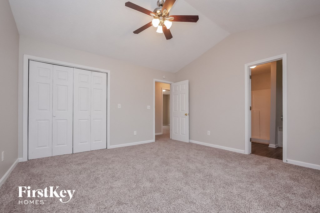 the living room of an empty house with a ceiling fan