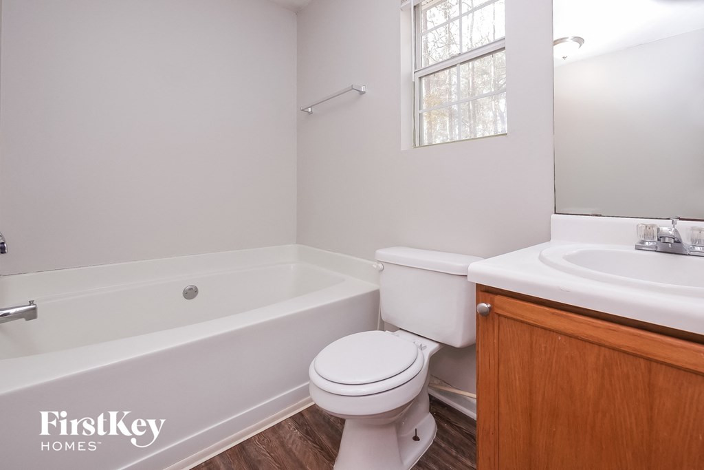 a bathroom with a toilet and a sink and a bath tub